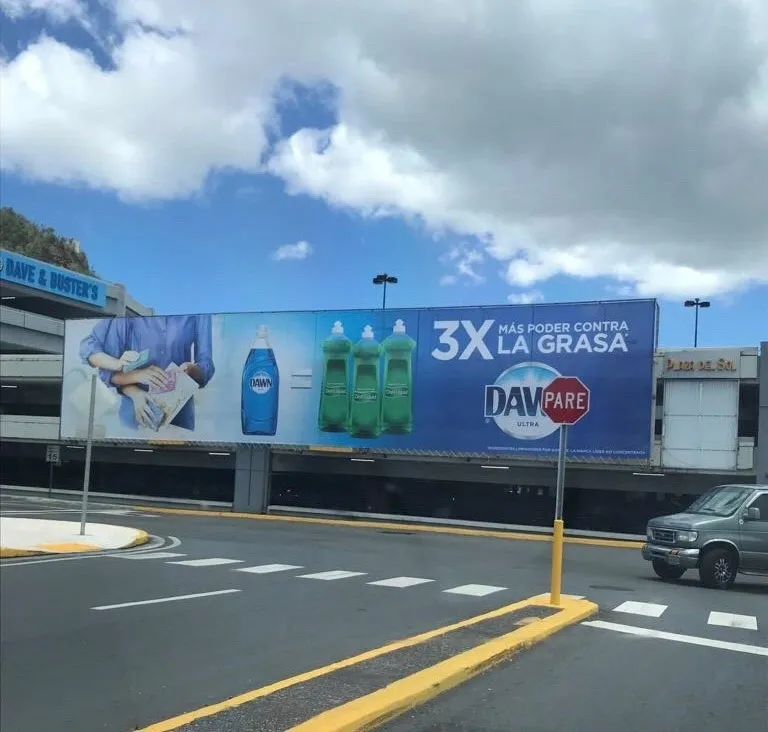 A billboard with a car in front of it.