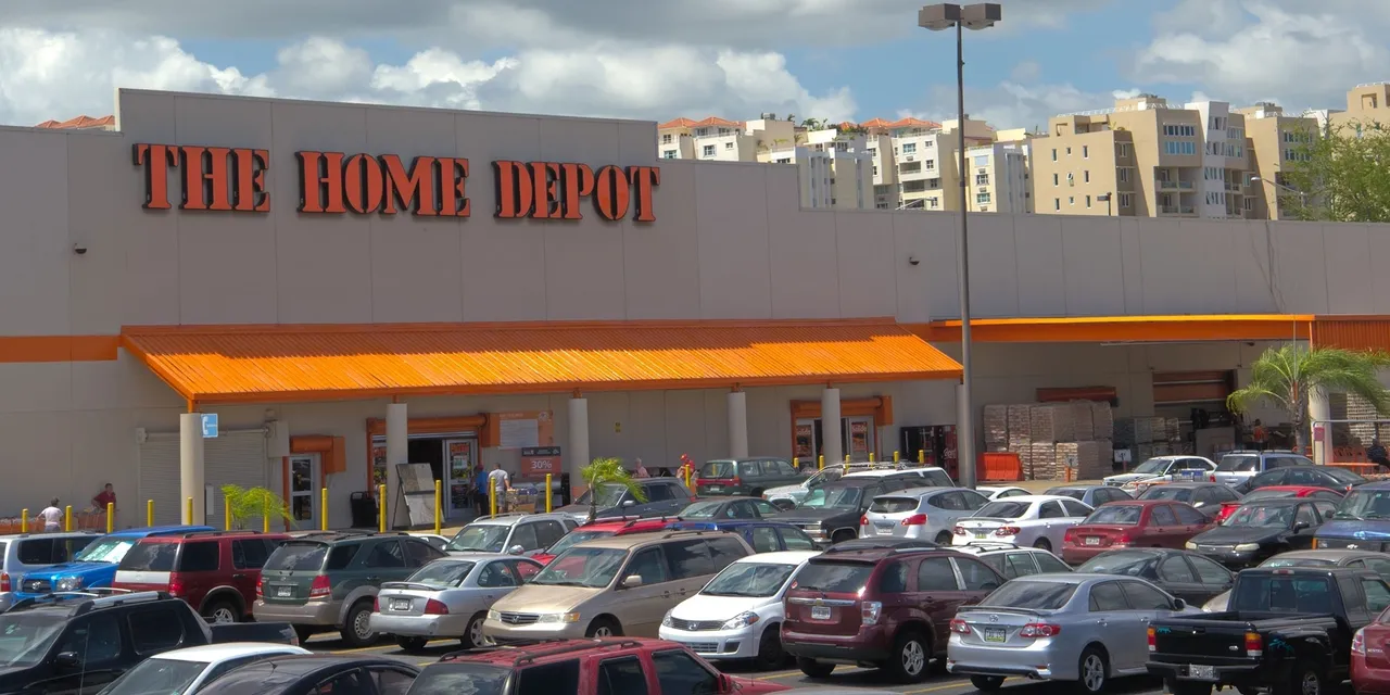 The home depot has a lot of cars parked in front of it.