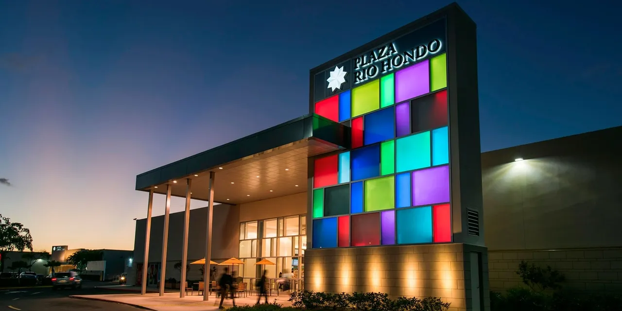 The entrance to a shopping center at night.