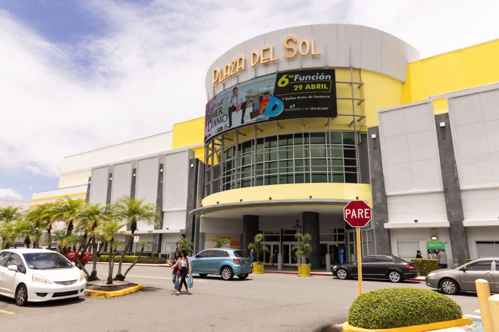 A yellow building with cars parked in front of it.