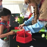 A woman and a child are making crafts at a table.